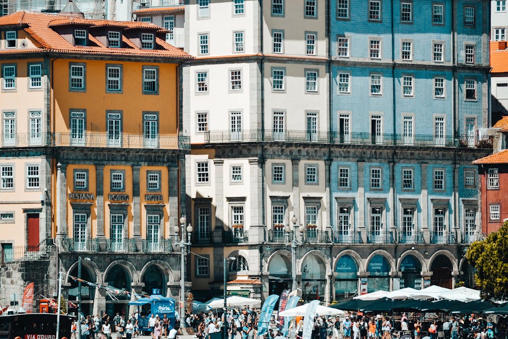Colorful buildings of Porto's Ribeira district on a sunny day with tourists below.